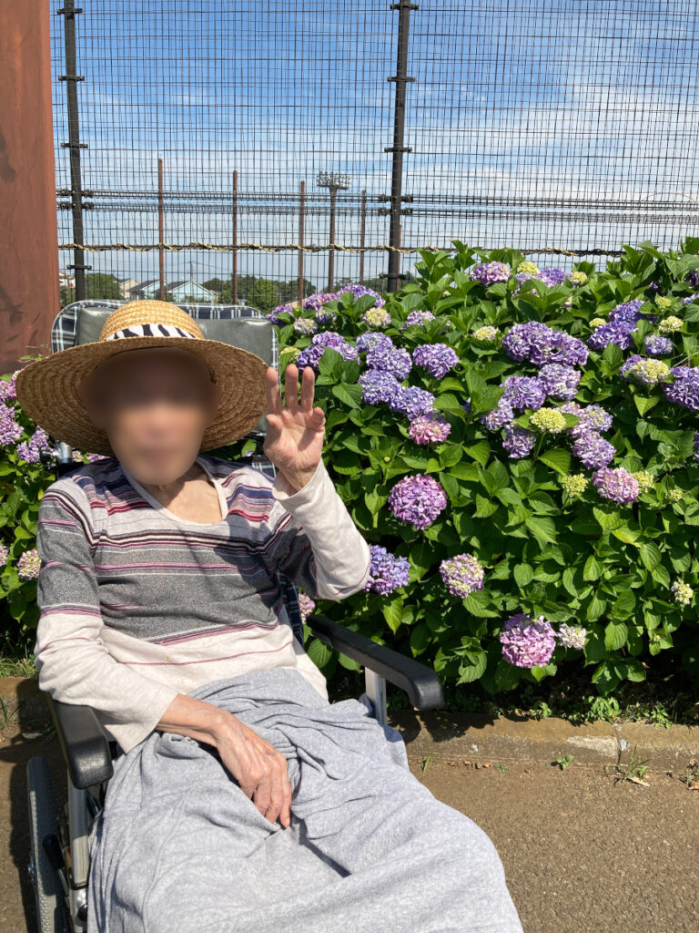 特別養護老人ホーム ル・リアンふかみの外出レクリエーションの様子です。瀬谷本郷公園に咲いているあじさいと、ポーズをとってくださるご利用者様。