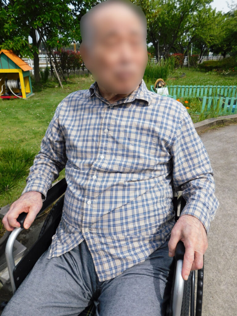 特別養護老人ホーム　ル・リアンふかみの施設庭園を、車いすで散歩するご利用者様の写真です。