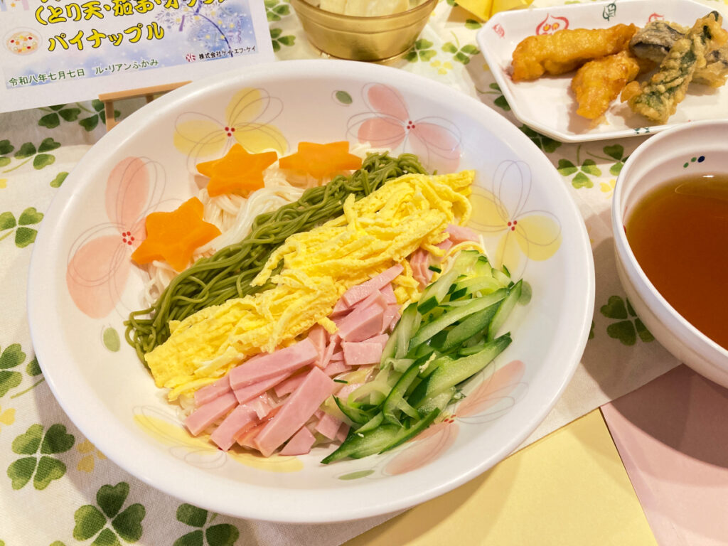 特別養護老人ホーム ル・リアンふかみの7月7日(火)の昼食「七夕そうめん」のアップの写真です。錦糸卵、ハム、きゅうり、星形にんじんで「天の川」を表現しました!