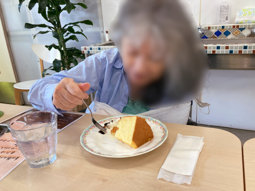 特別養護老人ホーム　ル・リアンふかみの外出レクリエーションの様子です。カフェの席で、シフォンケーキを召し上がるご利用者様です。