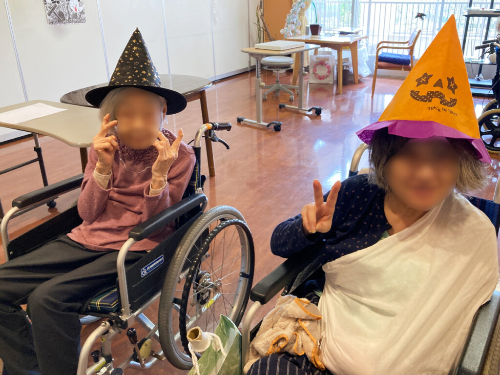 特別養護老人ホーム ル・リアンふかみで、令和8年10月13日(火)に行った「ハロウィンレクリエーション」の様子です。魔法使いの帽子で仮装したご利用者様がポーズをとっています!